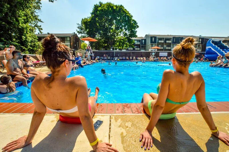 Two women relaxing at a Resort-style swimming pool with sun deck
